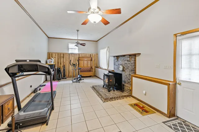 a view of a lake with lawn chairs and large trees
