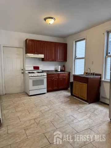 a kitchen with stainless steel appliances granite countertop a stove top oven a sink a counter space and cabinets