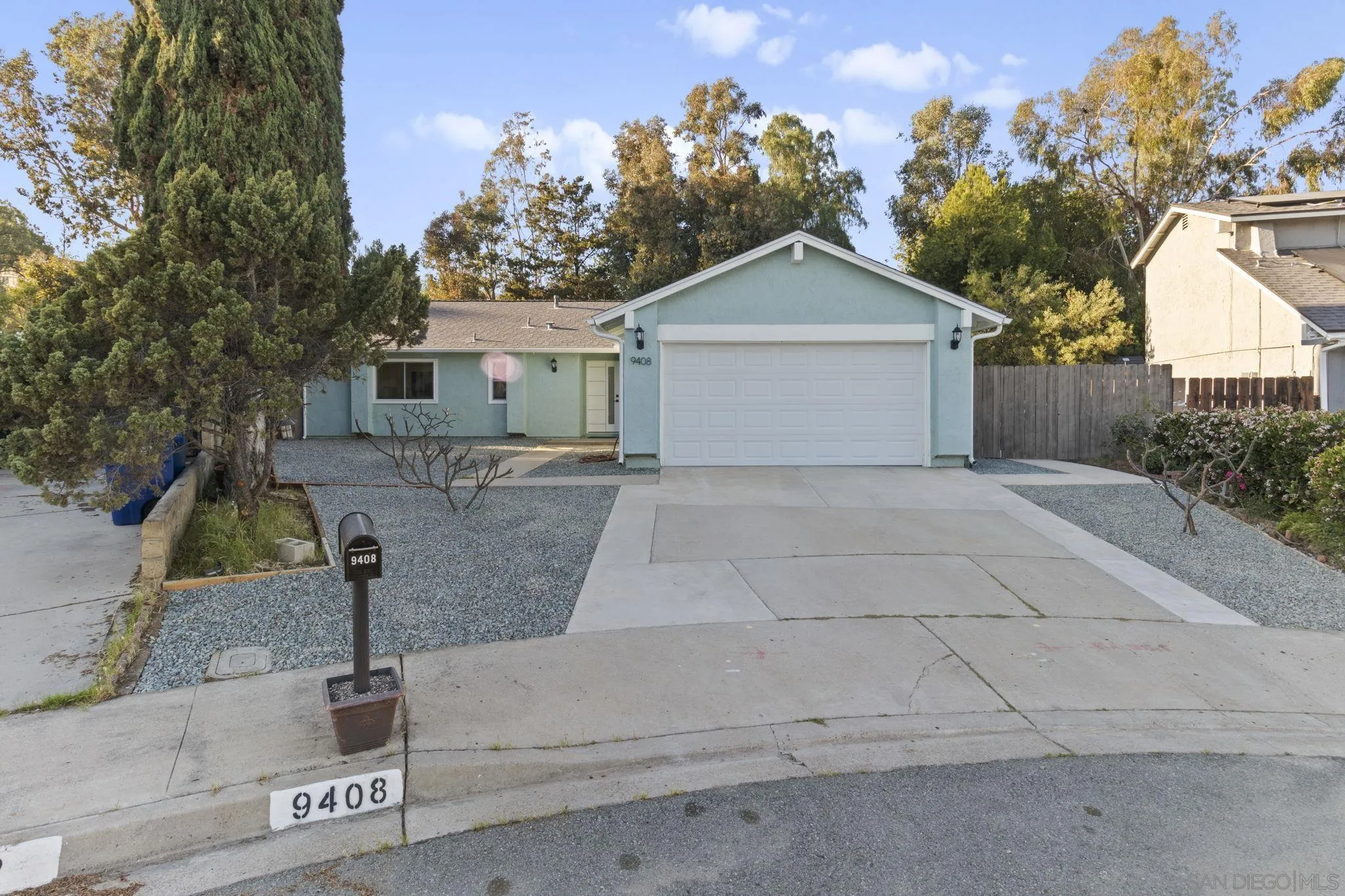 a view of a house with a yard and large tree
