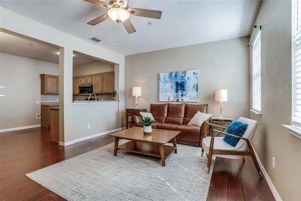 a living room with furniture and a wooden floor