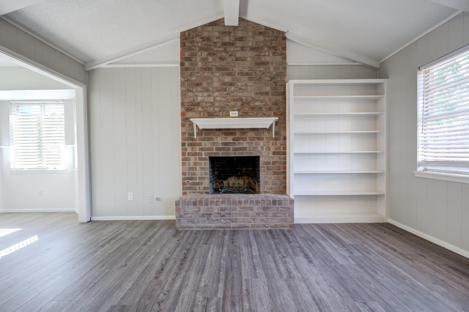 2314 79th Street Lubbock, TX 79423 - Photo 17 of 33 a view of an empty room with a fireplace and a window