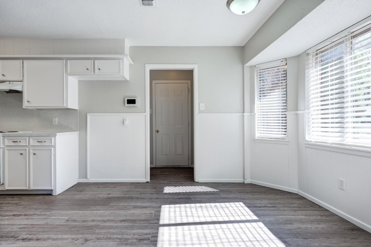 2314 79th Street Lubbock, TX 79423 - Photo 20 of 33 a view of a kitchen with white cabinets and wooden floor