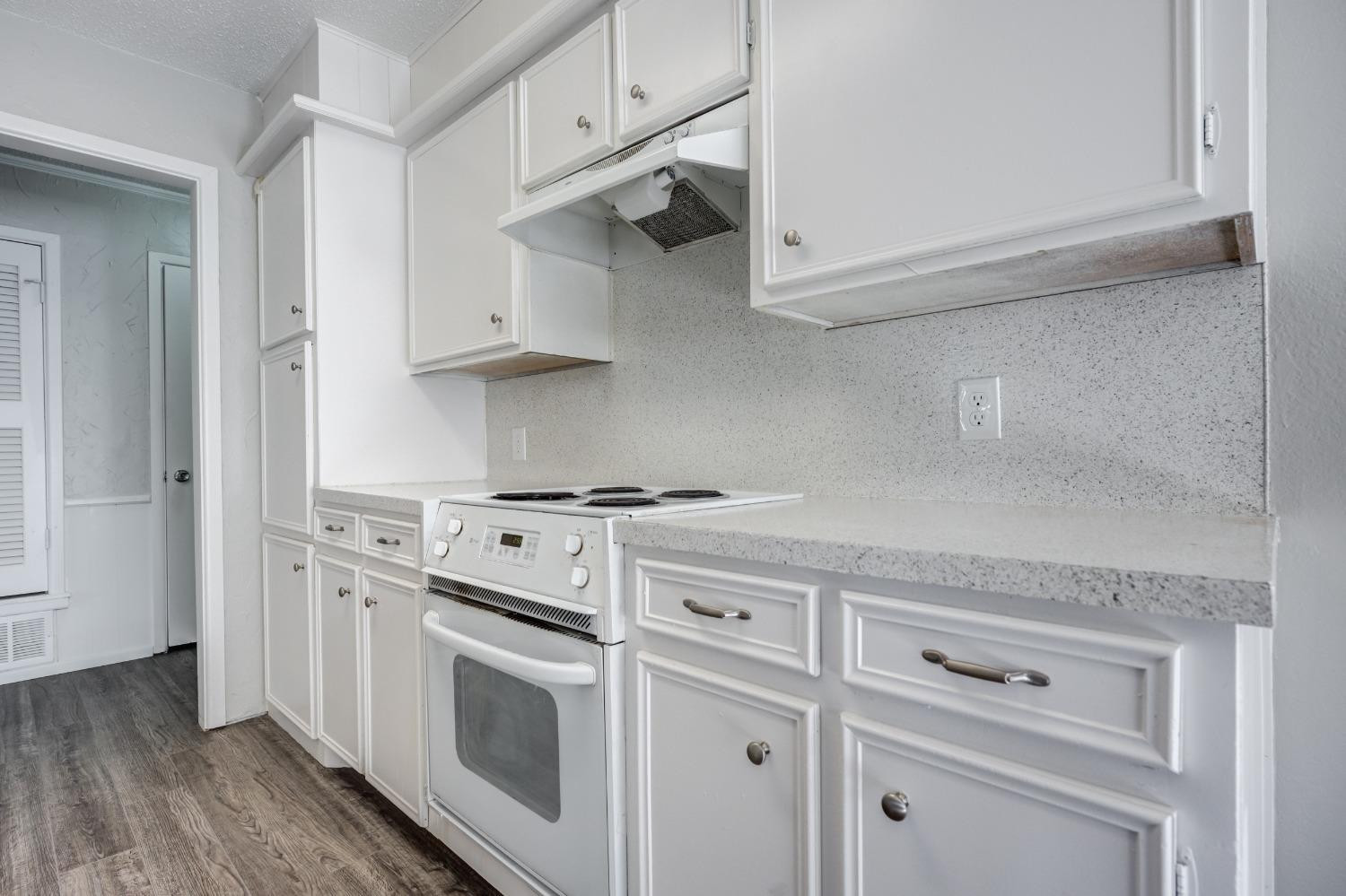 2314 79th Street Lubbock, TX 79423 - Photo 23 of 33 a kitchen with white cabinets and white appliances