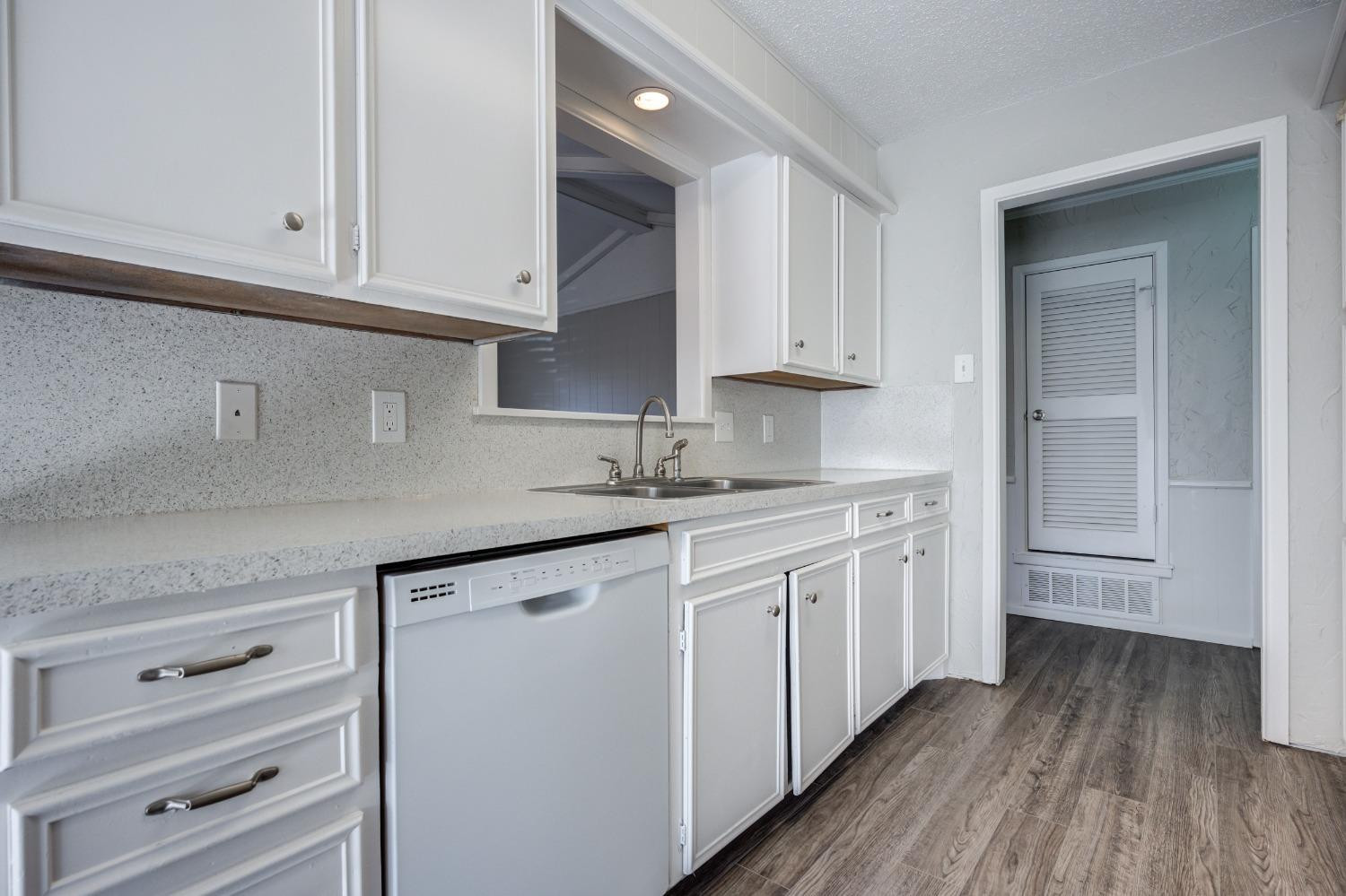 2314 79th Street Lubbock, TX 79423 - Photo 24 of 33 a kitchen with granite countertop white cabinets and white appliances
