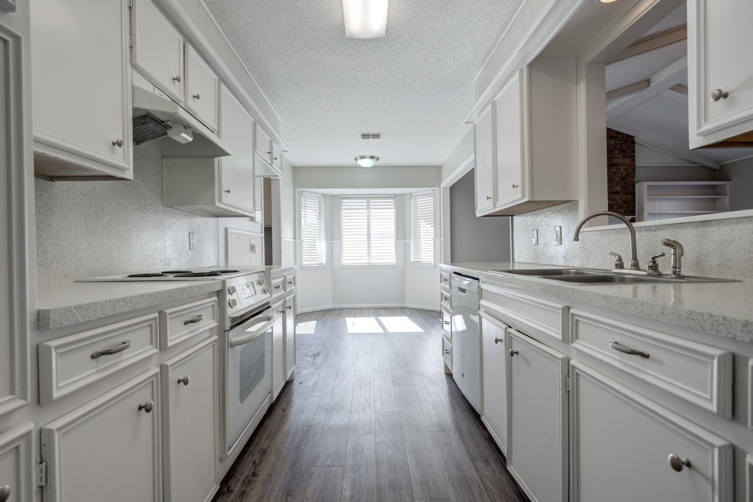 2314 79th Street Lubbock, TX 79423 - Photo 25 of 33 a kitchen with granite countertop a sink stove and cabinets