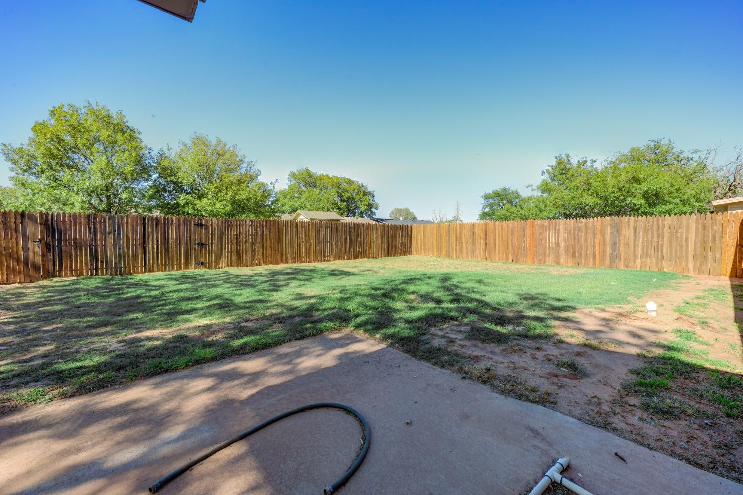 2314 79th Street Lubbock, TX 79423 - Photo 31 of 33 a view of a backyard with large tree and wooden fence