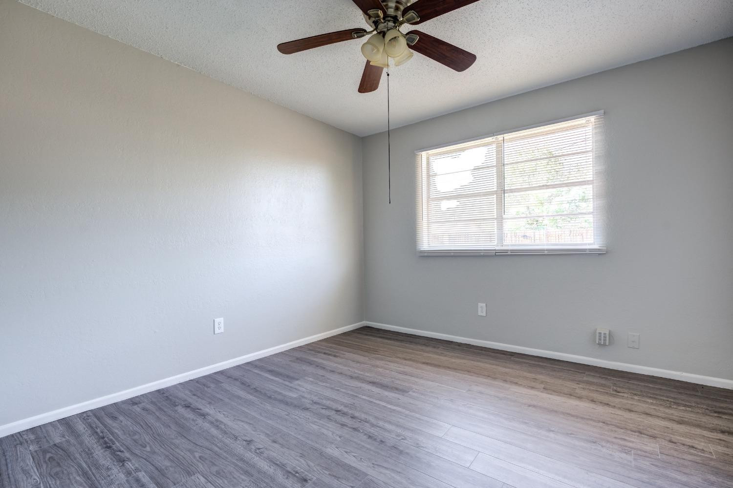 2314 79th Street Lubbock, TX 79423 - Photo 4 of 33 a view of an empty room with wooden floor and a window