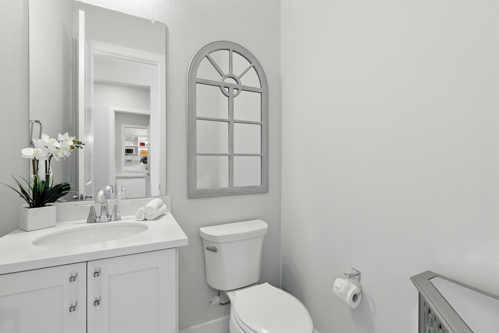 26923 Arethusa Court Spring, TX 77389 - Photo 20 of 44 A modern, guest bathroom with a sleek white vanity, chrome fixtures, and a decorative mirror. create a clean, spacious feel. Perfect for a stylish, functional space.