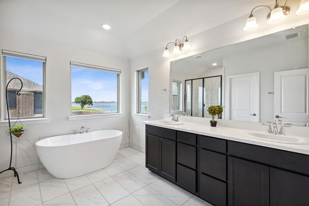 18142 Lakefront Court Forney, TX 75126 - Photo 21 of 26 a spacious bathroom with a double vanity sink mirror and bathtub