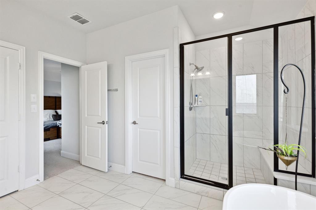 18142 Lakefront Court Forney, TX 75126 - Photo 22 of 26 a bathroom with a glass shower door