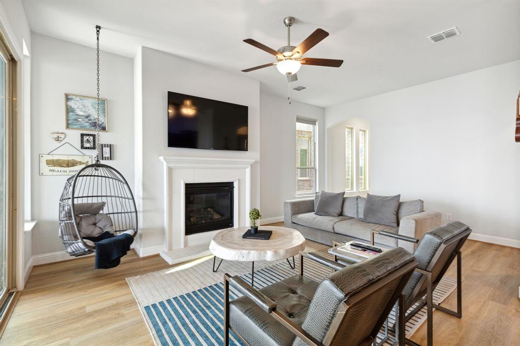 18142 Lakefront Court Forney, TX 75126 - Photo 5 of 26 a living room with furniture a flat screen tv and a fireplace