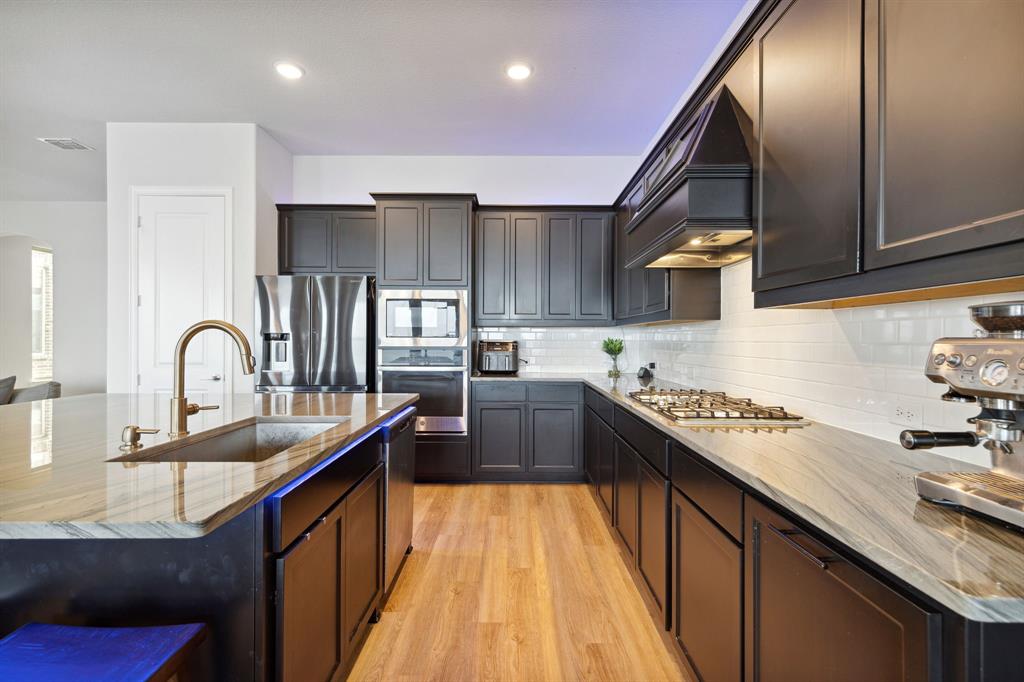 18142 Lakefront Court Forney, TX 75126 - Photo 8 of 26 a kitchen with stainless steel appliances granite countertop sink stove top oven and cabinets