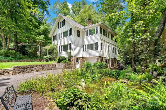 a front view of a house with a yard and trees