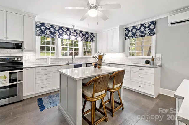 a kitchen with a refrigerator a stove a sink and dishwasher with a dining table