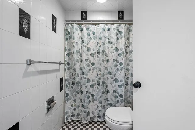 a white toilet sitting next to a shower curtain