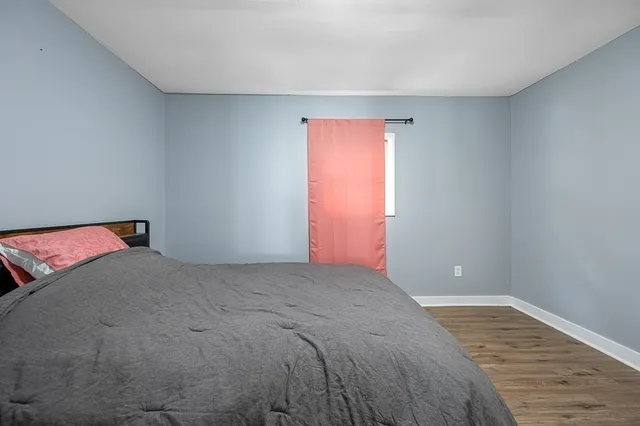 a bedroom with a bed and wooden floor