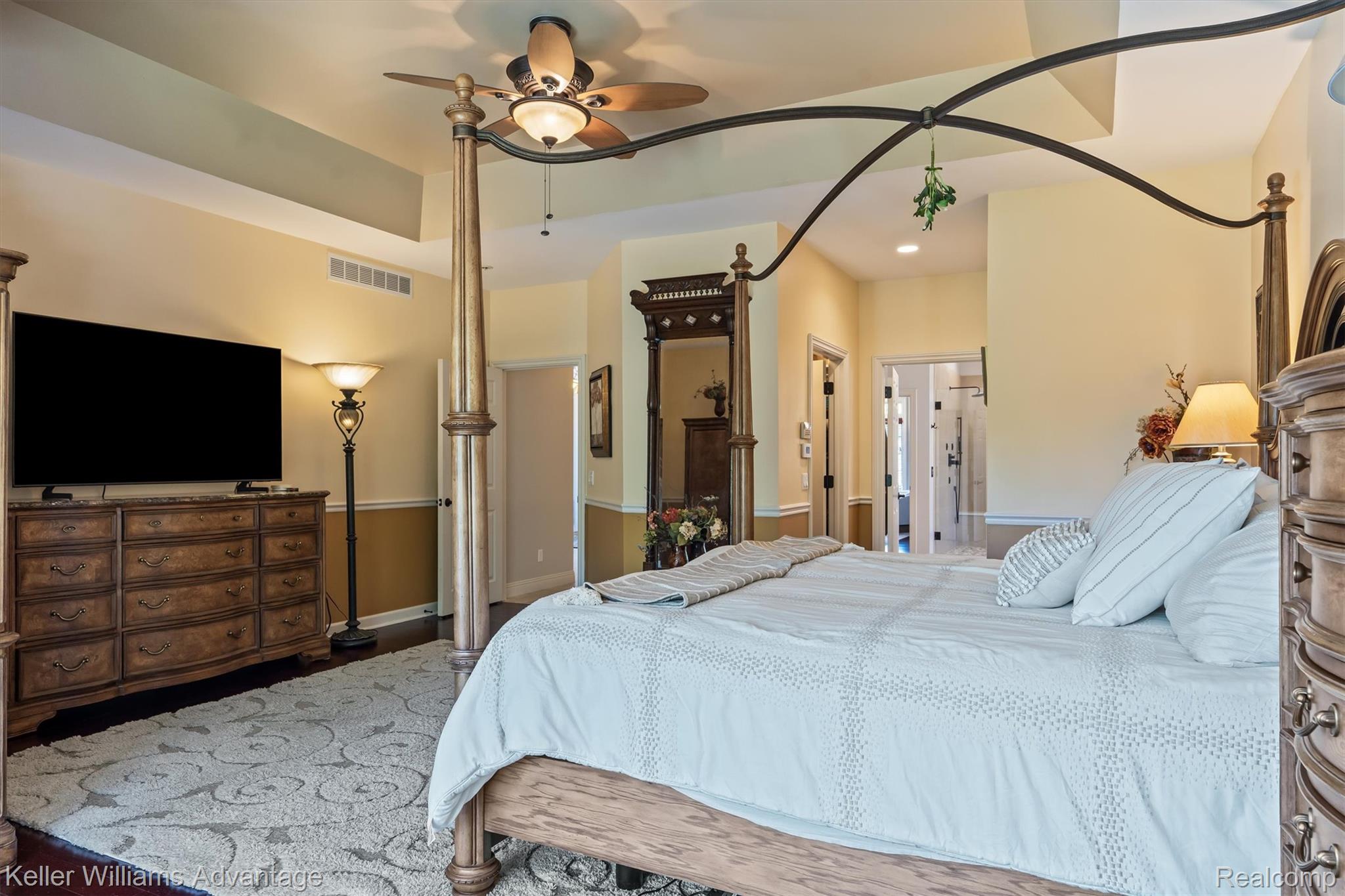 22878 Tree Top Court South Lyon, MI 48178 - Photo 18 of 75 Spacious room featuring tray ceilings, a ceiling fan with integrated lighting, recessed lighting, and wood-finish flooring