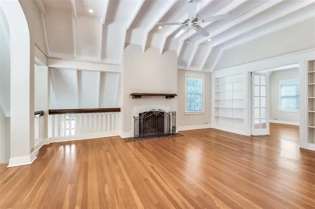 a view of empty room with wooden floor and fireplace