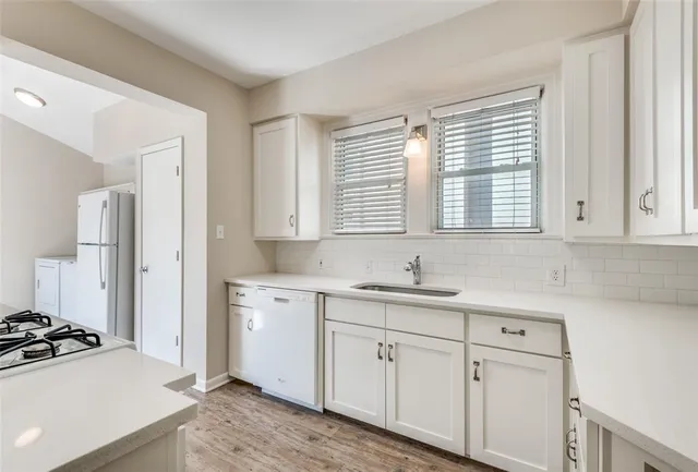 a kitchen with a sink cabinets appliances and a window