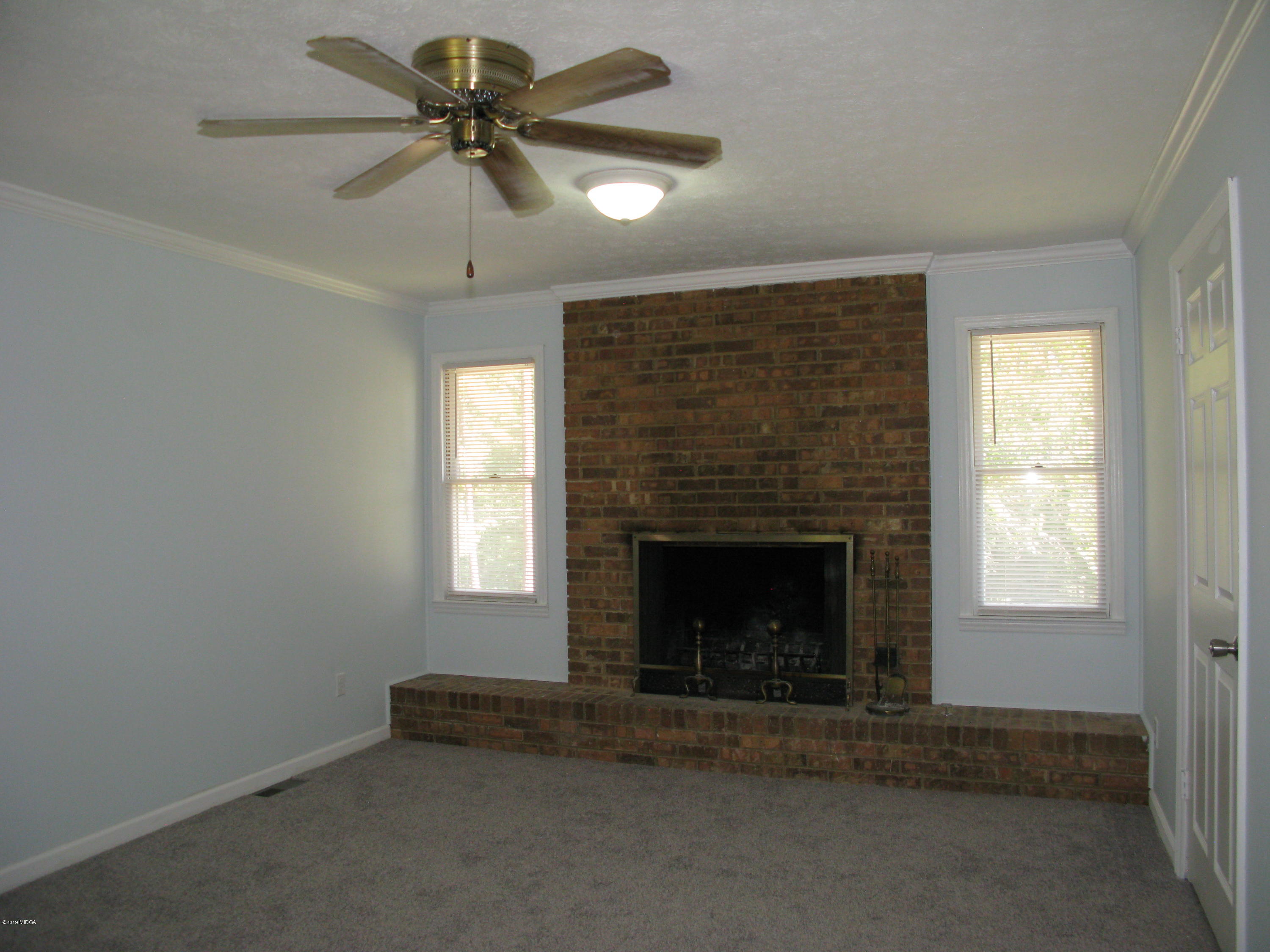 3812 Western Way Macon, GA 31216 - Photo 4 of 29 an empty room with windows and fireplace