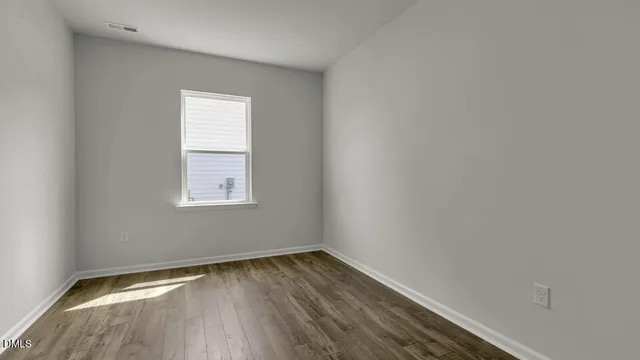 a view of a room that has wooden floor and windows in it