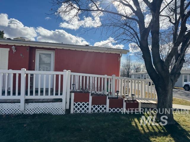910 Moonglo, Unit 49 Buhl, ID 83316 - Photo 5 of 16 View of property exterior with a deck and a lawn
