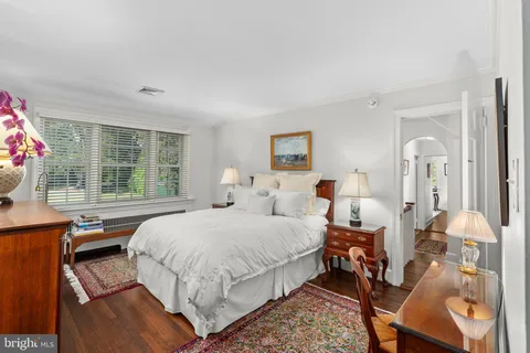 a bedroom with a bed a table and windows