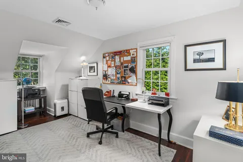 a view of a workspace with furniture and a window
