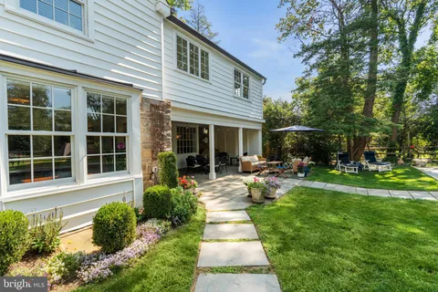 a front view of a house with fountain and garden