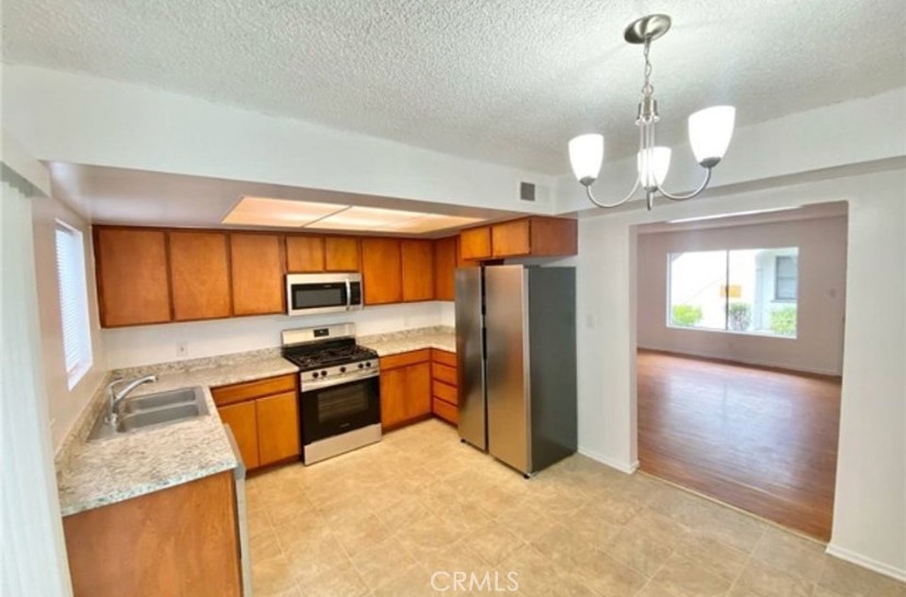 4237 Dixie Canyon Avenue, Unit 2 Sherman Oaks, CA 91423 - Photo 3 of 9 a kitchen with stainless steel appliances granite countertop a refrigerator a sink dishwasher a stove with wooden cabinets and floor
