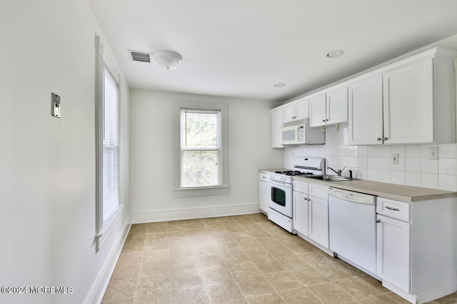 94 Branch Avenue Red Bank, NJ 07701 - Photo 13 of 21 a kitchen with granite countertop white cabinets and white appliances