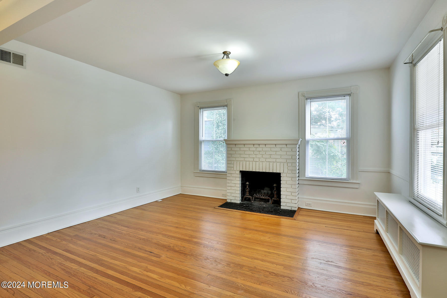 94 Branch Avenue Red Bank, NJ 07701 - Photo 4 of 21 a view of empty room with wooden floor and fireplace
