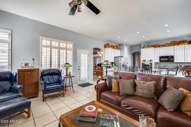 a living room with furniture a flat screen tv and kitchen view