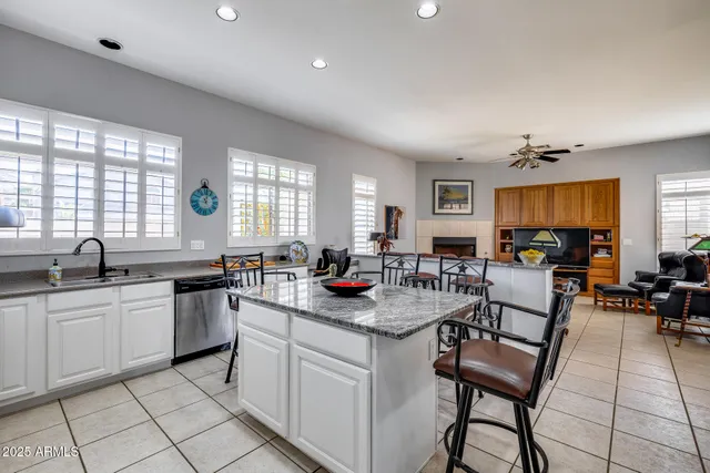 a kitchen with stainless steel appliances a dining table chairs microwave and sink