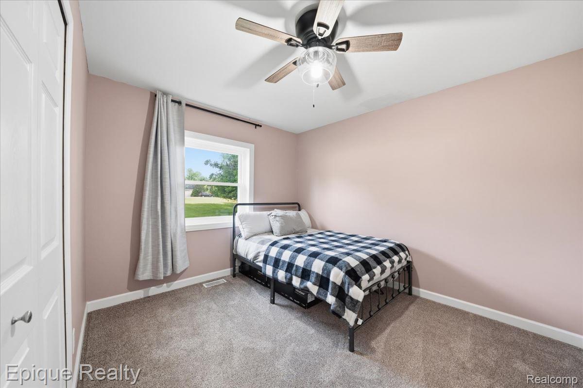 12272 East Mt Morris Road Davison, MI 48423 - Photo 16 of 39 Carpeted room featuring a white-trimmed window, a ceiling fan with light fixture, and a white bi-fold closet door
