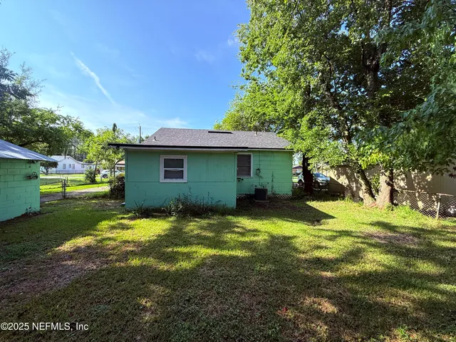 a green field covered with tall trees