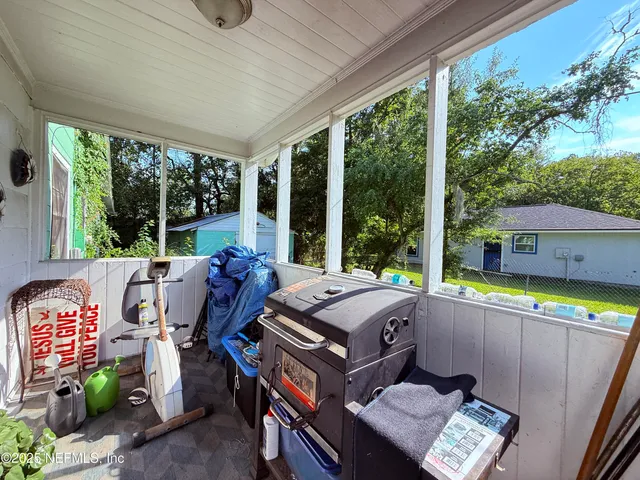 a living room with patio furniture and a floor to ceiling window