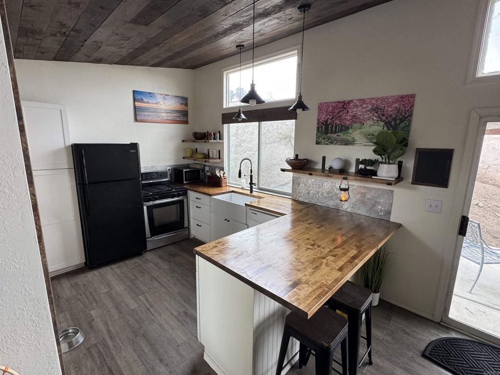 2494 Donnil Lane Fallbrook, CA 92028 - Photo 14 of 62 a kitchen with stainless steel appliances wooden floor dining table and chairs
