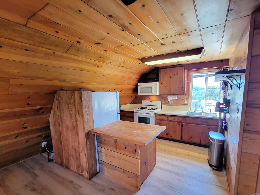 2494 Donnil Lane Fallbrook, CA 92028 - Photo 8 of 62 a kitchen with stainless steel appliances wooden floors and wooden cabinets