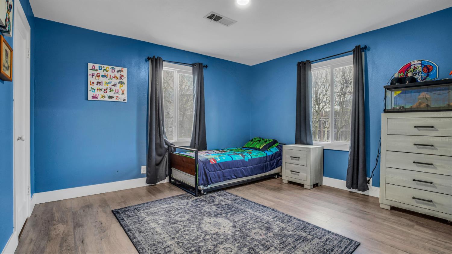 2331 East Woodson Road Acampo, CA 95220 - Photo 22 of 59 a bedroom with a bed and wooden floor