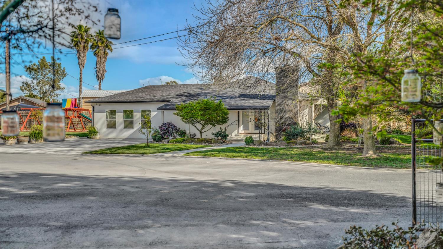 2331 East Woodson Road Acampo, CA 95220 - Photo 35 of 59 a front view of a house with a yard and potted plants