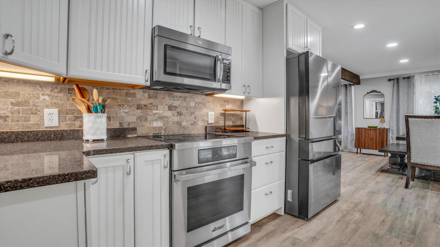 2331 East Woodson Road Acampo, CA 95220 - Photo 10 of 59 a kitchen with granite countertop a refrigerator stove and microwave