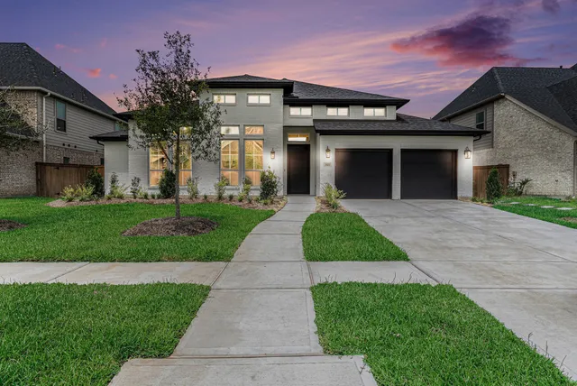a front view of a house with a yard and potted plants
