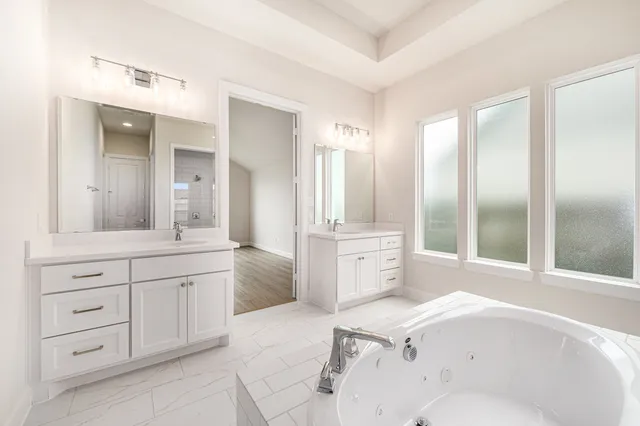 a spacious bathroom with a granite countertop sink mirror and bathtub