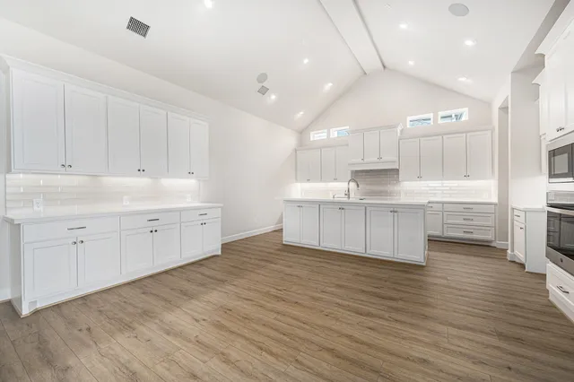 a large kitchen with stainless steel appliances granite countertop a large center island and a sink