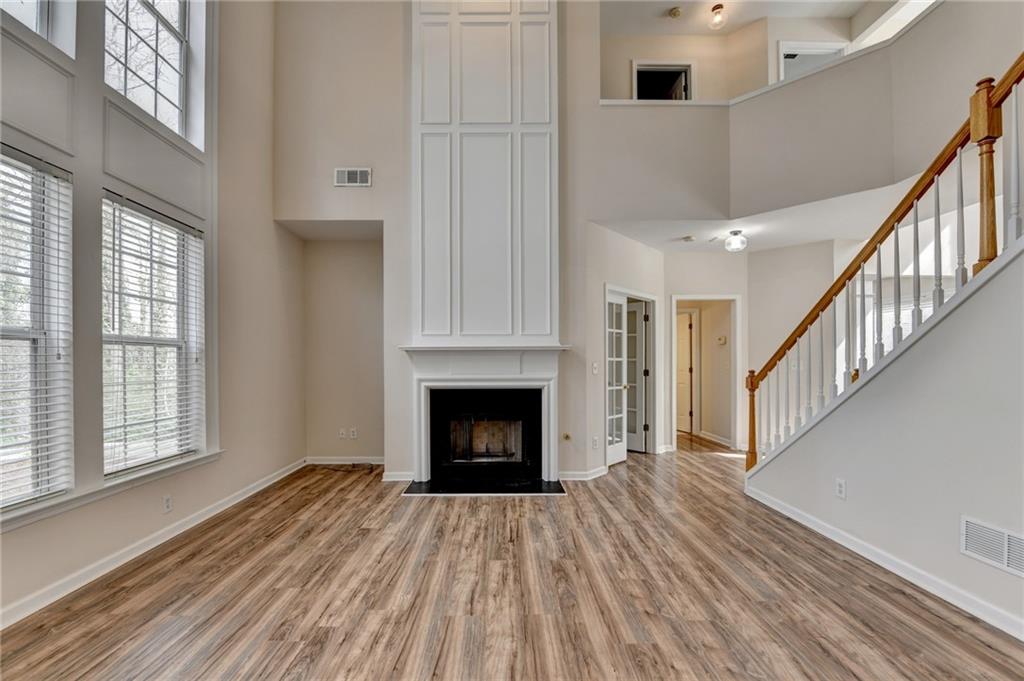 100 Hawnley Trc Northwest Suwanee, GA 30024 - Photo 17 of 58 a view of an empty room with wooden floor fireplace and a window
