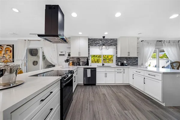 a kitchen with kitchen island granite countertop a sink a counter space appliances and cabinets