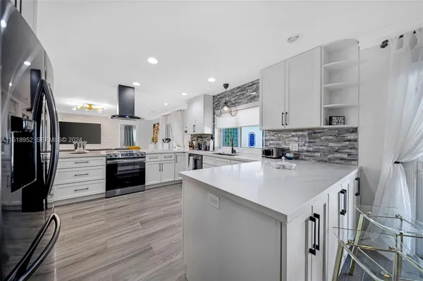 a kitchen with stainless steel appliances kitchen island a sink and a stove