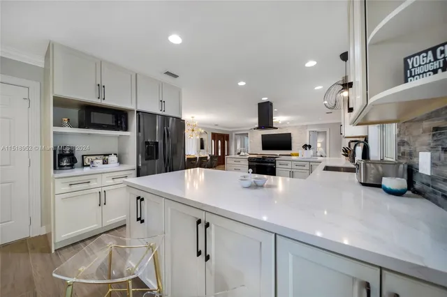 a kitchen with a sink stainless steel appliances and white cabinets