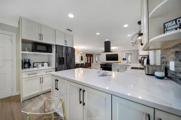 a kitchen with a sink stainless steel appliances and white cabinets